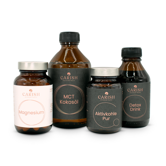 Man sieht die Produkte des Detox Paket. Ganz links die Magnesium Kapseln, dann das MCT Kokosöl, die Aktivkohlekapseln und rechts den Detox Drink. Alle Produkte in einer dunkelbraunen Glasverpackung mit Etikett.