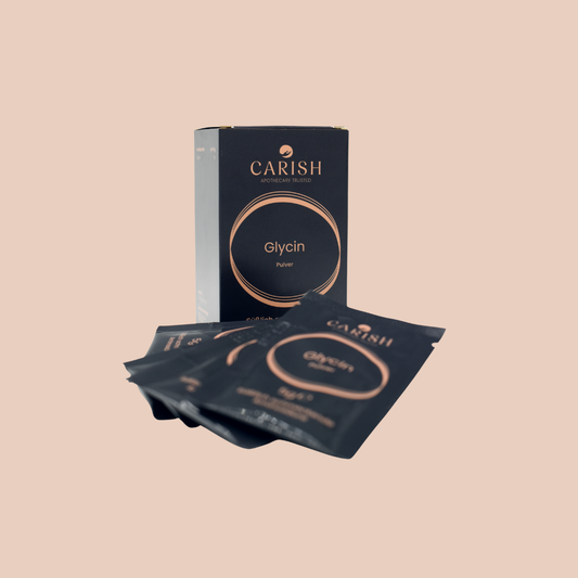 Die Glycinsachets in Reisegröße zum Mitnehmen. Eine schwarze Papierverpackung und im Vordergrund liegen 5 Sachets zur Ansicht.