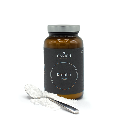 Die dunkelbraune Glasverpackung des Kreatin Pulvers und im Vordergrund loses Pulver auf einem Löffel zur Ansicht.