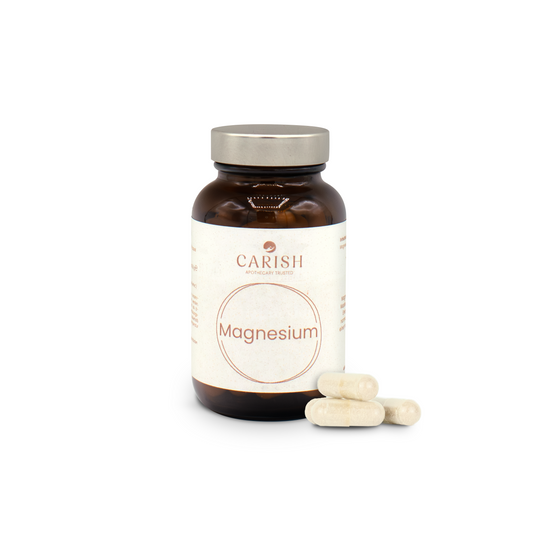 Brauner Glasbehälter mit weißem Etikett und verschraubbarem silbernen Deckel der Magnesium Kapseln gegen Krämpfe. Im Vordergrund liegen 3 weiße Kapseln zur Ansicht.