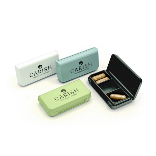 4 Pillendosen in verschiedenen Farben (weiß, blau, grün, schwarz) mit dem Carish Logo.