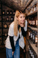 Die Apothekerin Nina Milenkovics steht im Apothekermantel vor einem Regal mit alten Apothekergefäßen. 