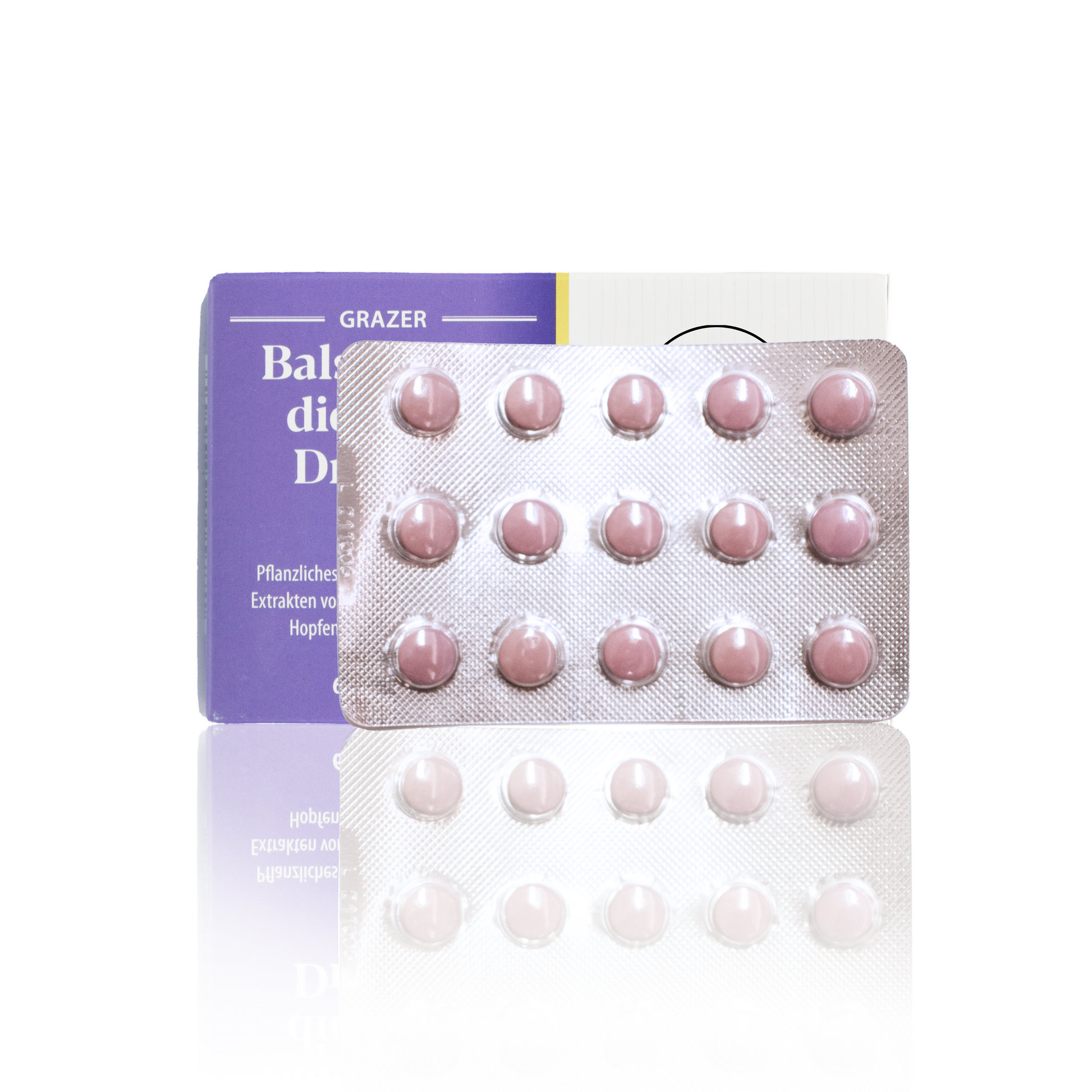 Weiß, lila Papierverpackung mit Logo und Beschreibung und im Vordergrund die rosa Tabletten gegen Seelenkummer.