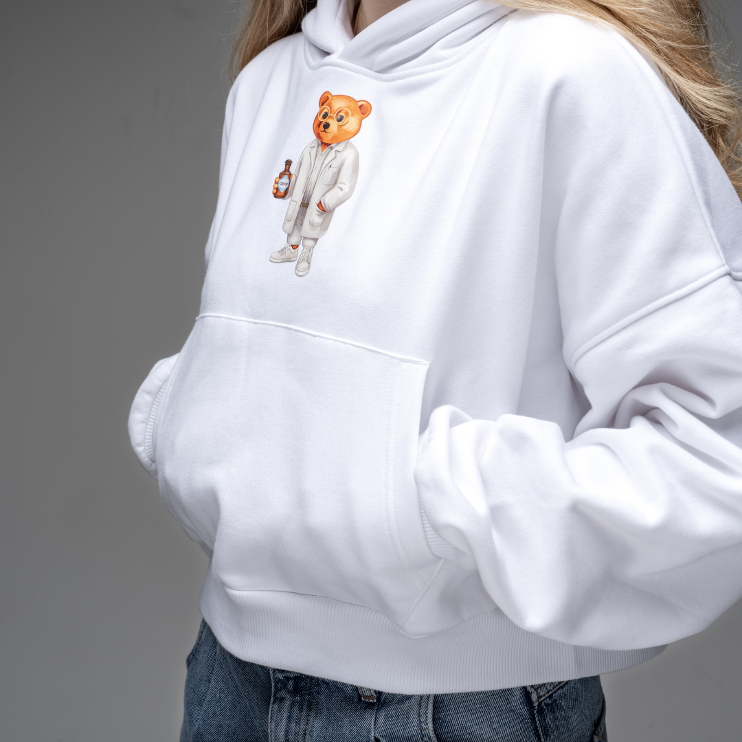 Der Baron Filou Pullover in Nahaufnahme in weiß mit dem Apothekerbär. 