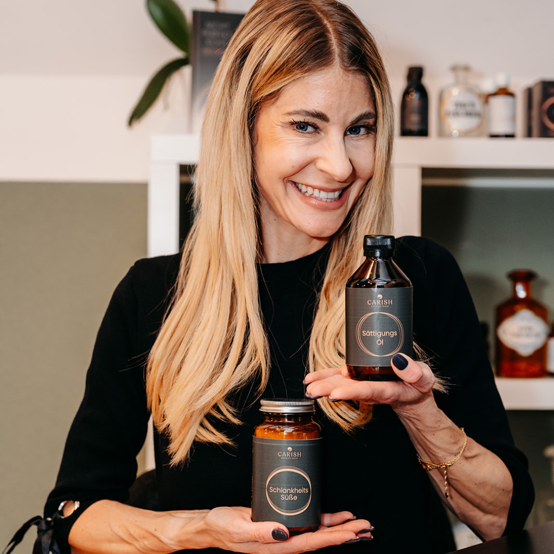 Die Apothekerin Nina Milenkovics lacht in die Kamera und hat die 2 Produkte des Fettkiller Pakets von Carish in ihren Händen. 