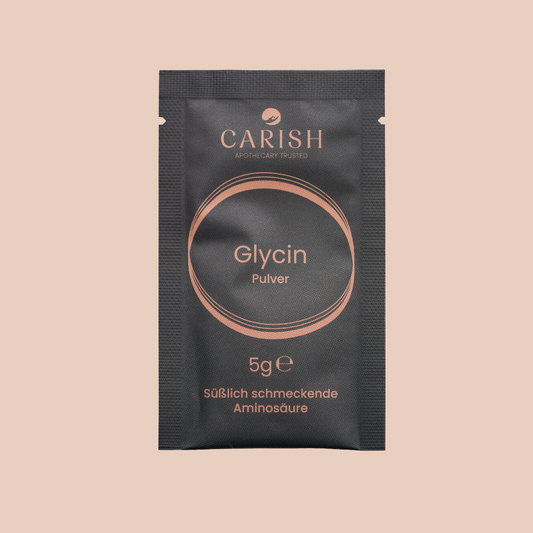 Das Glycin Pulver in Sachetform in einer schwarzen Verpackung. 