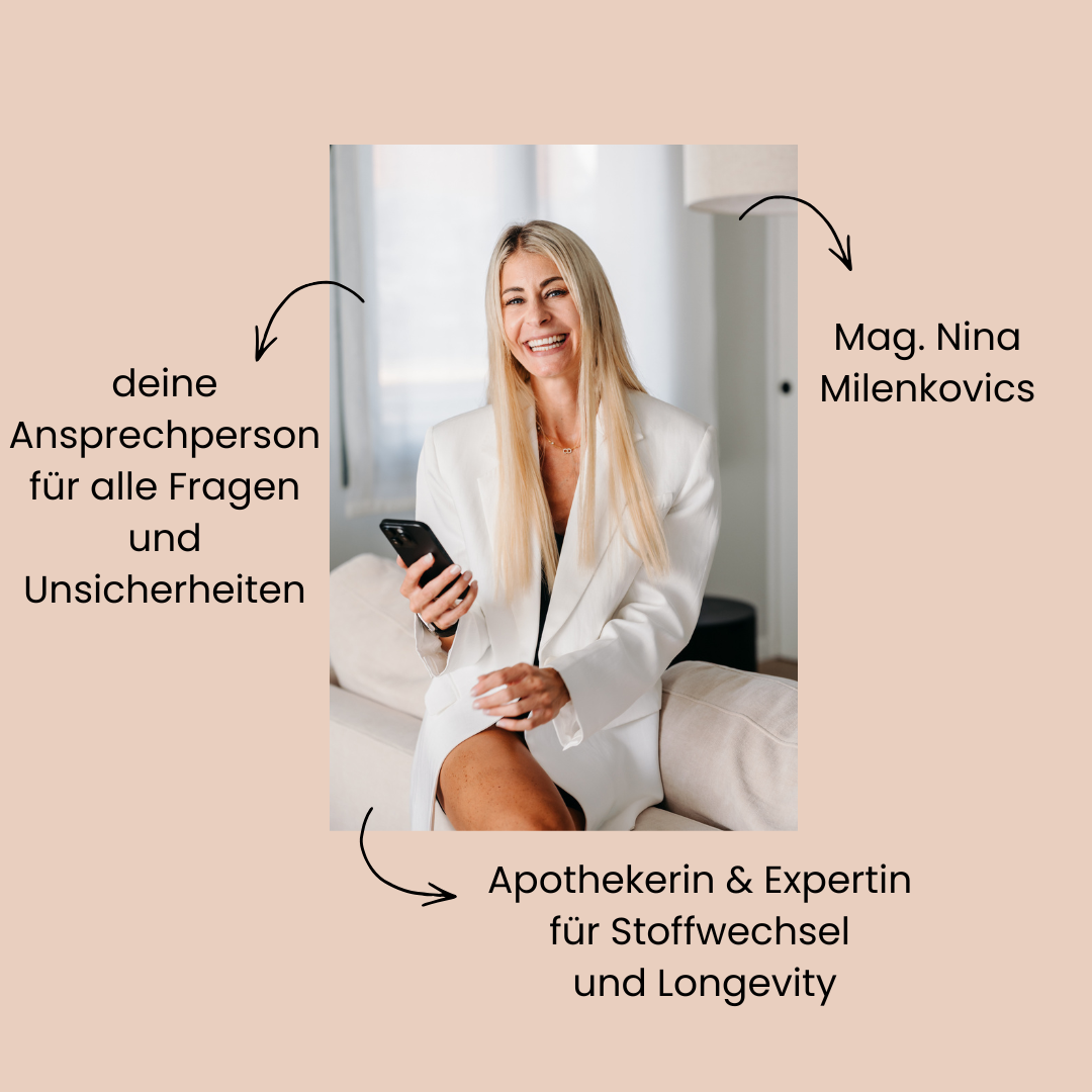 Die Apothekerin Nina Milenkovics sitzt auf einer weißen Couch, lächelt in die Kamera und hat ein Handy in ihrer rechten Hand. 