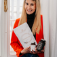 Die Apothekerin Nina Milenkovics steht vor einem Fenster und hat die 3 Produkte des Longevity Pakets von Carish in ihren Händen. 