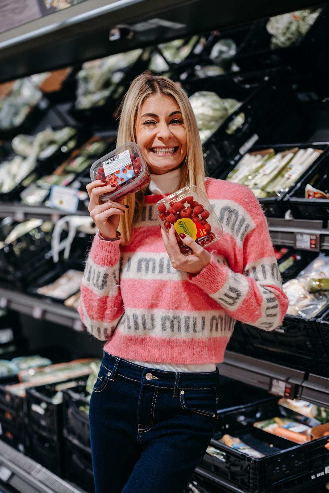 Nina Milenkovics in einem Supermarkt mit Himbeeren in der Hand.