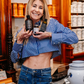 Die Apothekerin Nina Milenkovics steht vor einem Apothekerschrank und hält die 3 Produkte des Schlankheitspakets von Carish in die Kamera. 