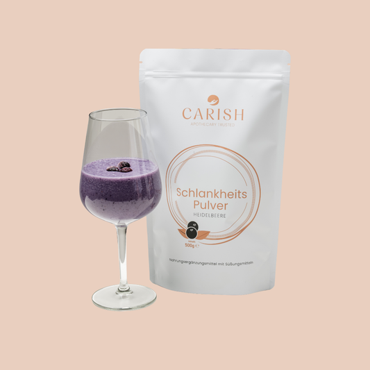 Das Schlankheitspulver Heidelbeere in einem weißen Sack. Im Vordergrund ein Weinglas mit einem angerührten Proteinpulver zur Ansicht. 