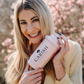 Nina Milenkovics hat einen rosa färbigen Shaker von Carish in der Hand und lacht in die Kamera. 