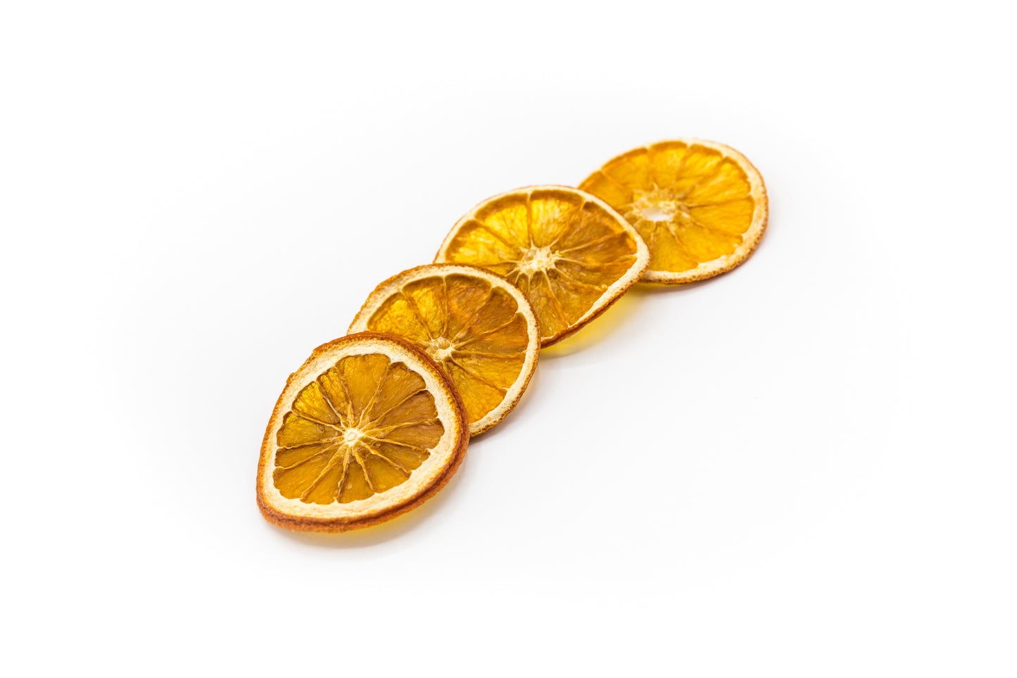 Vier aufgeschnittene, gedörrte Orangen auf weißem Hintergrund.